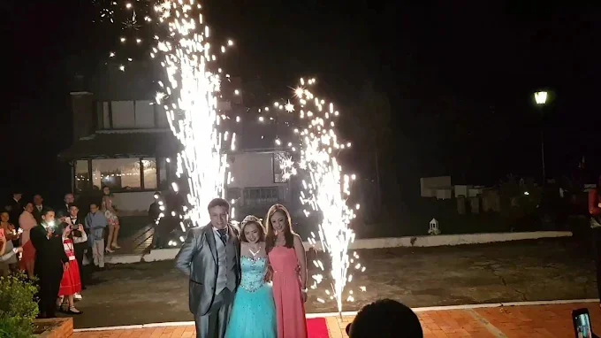 Quinceañera entrando al salón entre fuentes de chispas