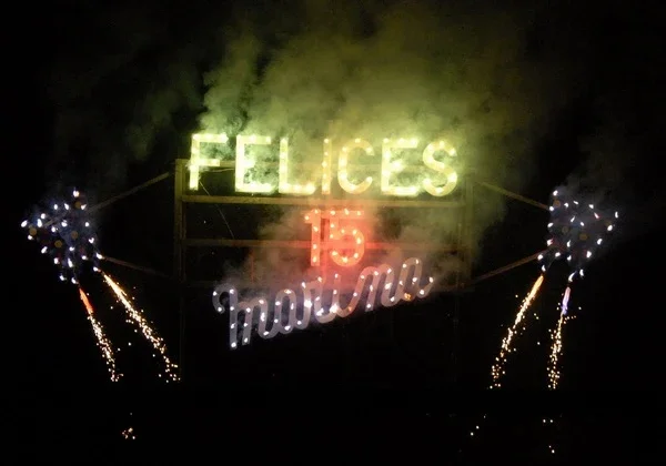 Letrero encendido con fuego que dice “15 años” en fiesta